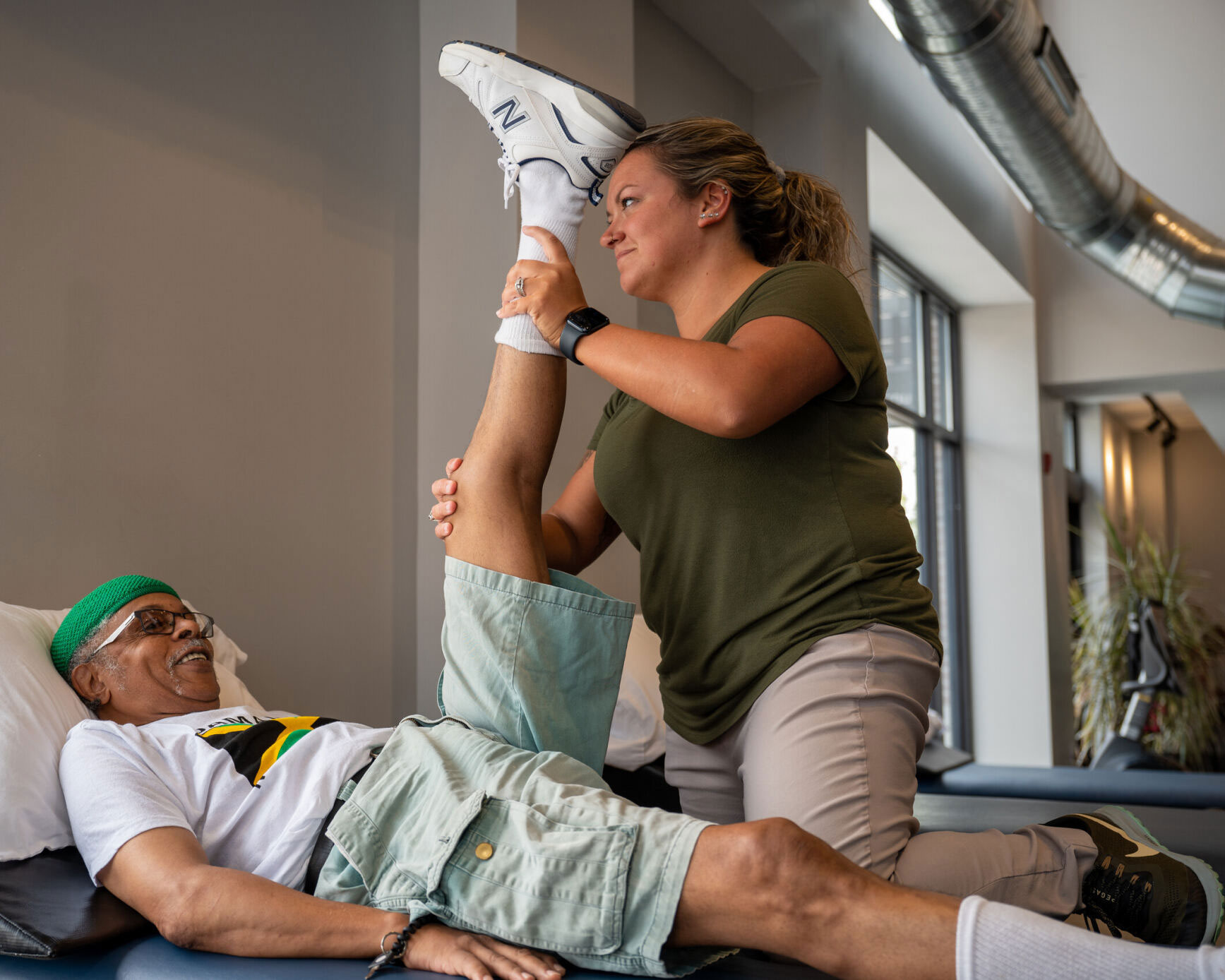 A Physical Therapist happily works on a knee patient.