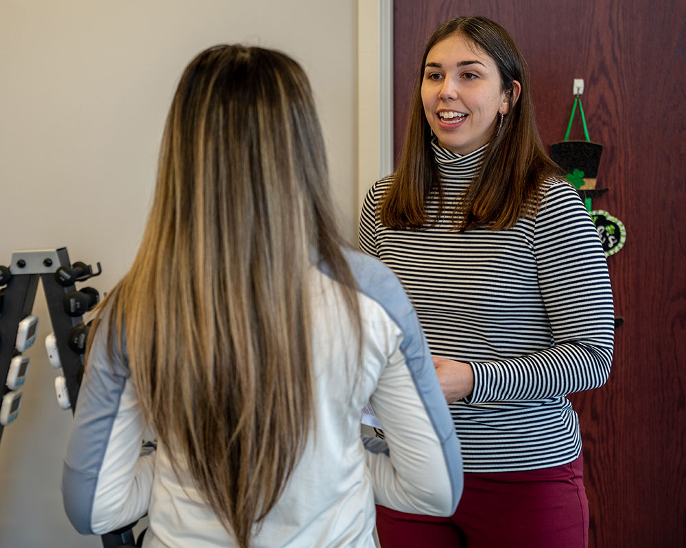 A Physical Therapist smiles at her patient.