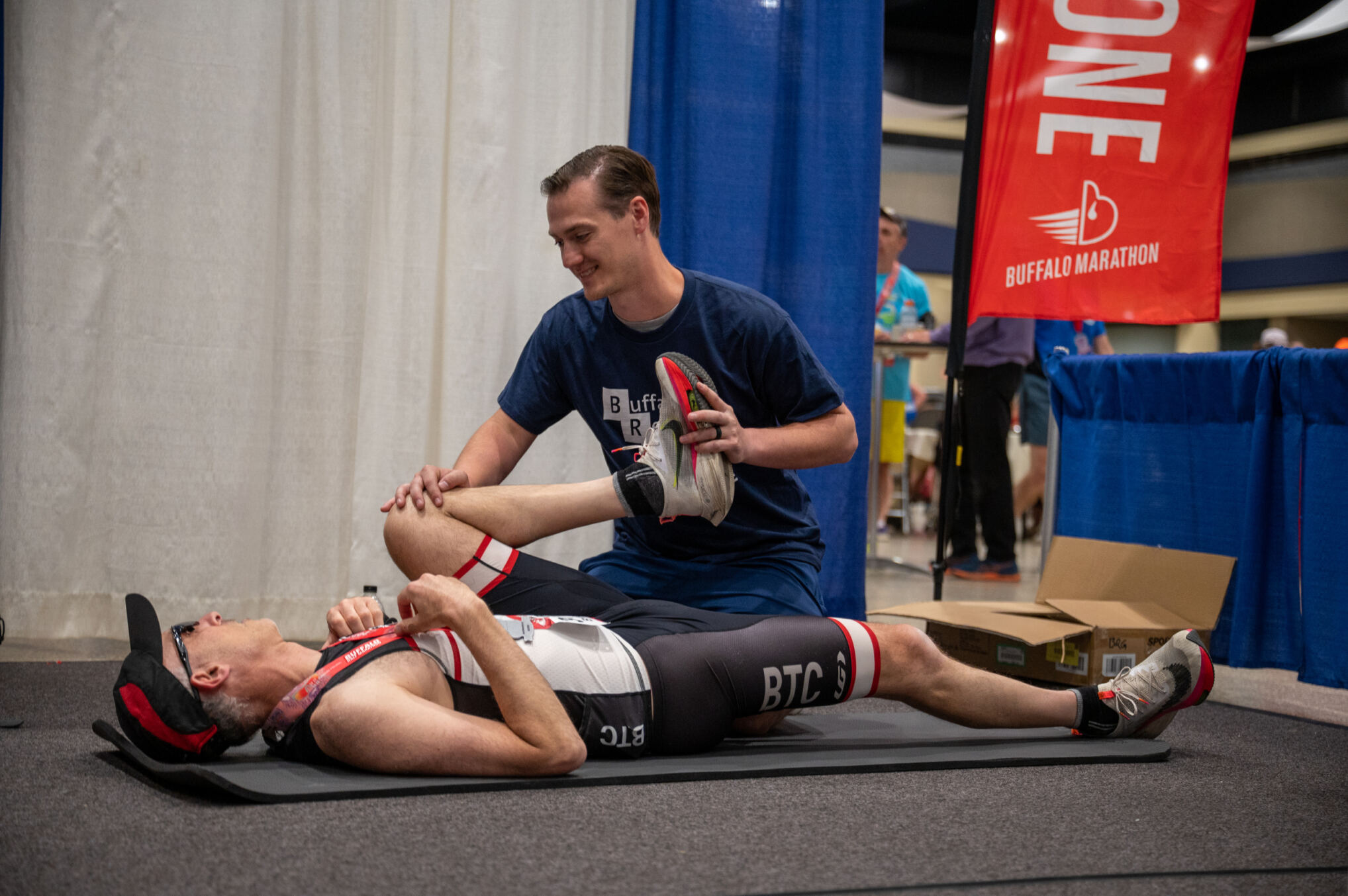A physical therapist smiles as she converses with her patient.