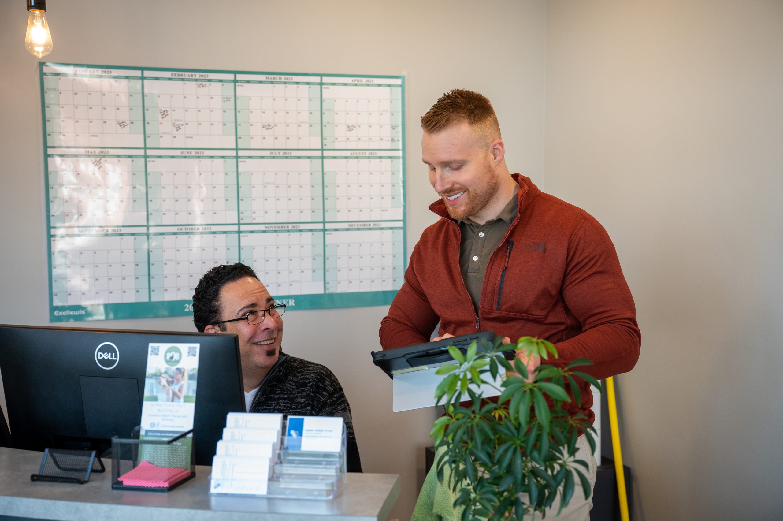 A physical therapist smiles as she converses with her patient.